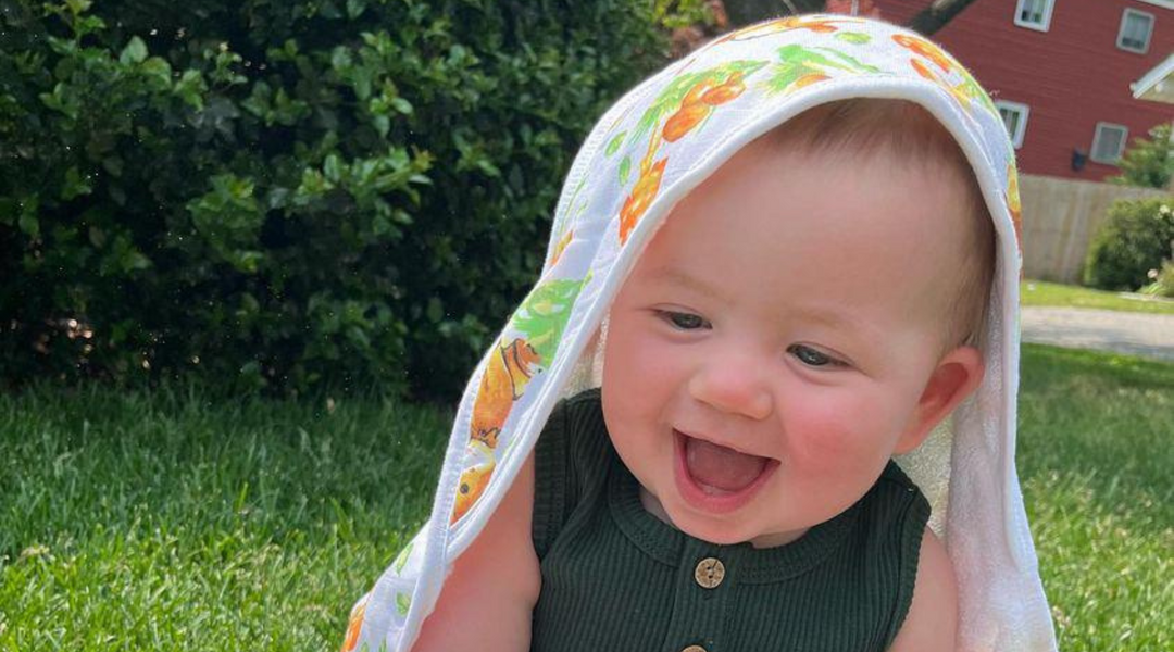 a happy baby wearing kloud bambu woodland bamboo hooded towel for fall season