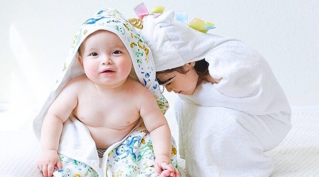 Siblings playing together while wrapped with kloud bambu bamboo baby hooded bath towels